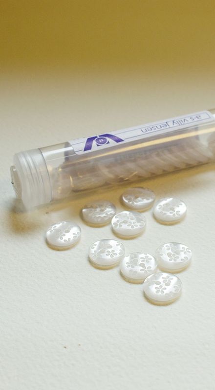 Hvit plastknapp med blomst 15 mm